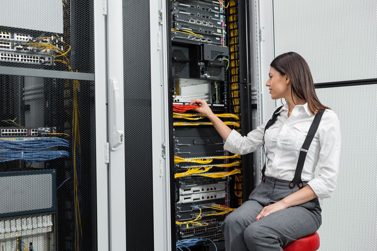 Young engineer businesswoman in network server room