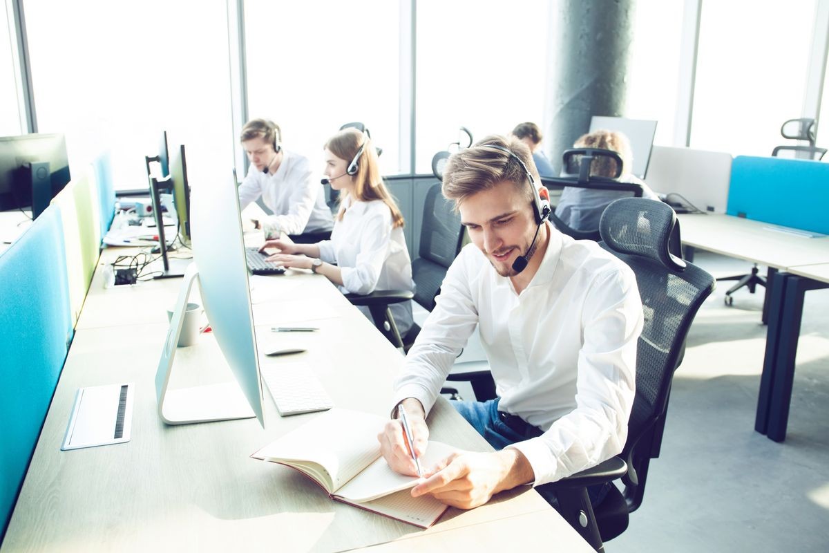 Happy young male customer support executive working in office